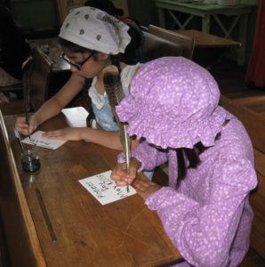 Children at desks in the Museum Schoolhouse